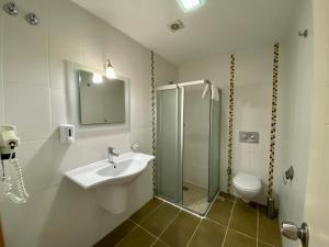 La salle de bains est pourvue d'un lavabo, d'une douche et de toilettes. dans l'établissement Konfor Suite Otel, à Ölüdeniz