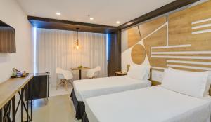 una camera d'albergo con due letti e un tavolo di Rio Design Copacabana Hotel a Rio de Janeiro