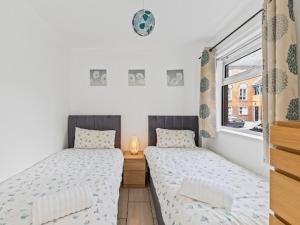 2 camas individuales en una habitación con ventana en Self Catering Belfast Apartment, en Belfast