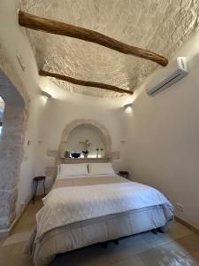 ein Schlafzimmer mit einem großen Bett und einer Steindecke in der Unterkunft Trulli Barsento in Alberobello