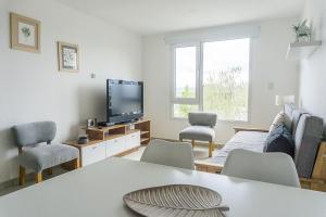 a living room with a table and chairs and a tv at Gente del Sur - Goleta in Ushuaia