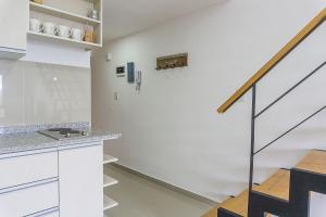 a kitchen with white cabinets and a staircase at Gente del Sur - Goleta in Ushuaia
