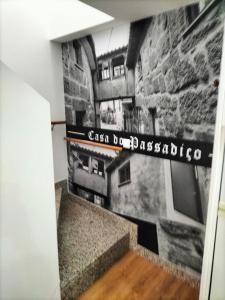 een kamer met een muur met een foto van een gebouw bij Casa do passadiço in Vieira do Minho