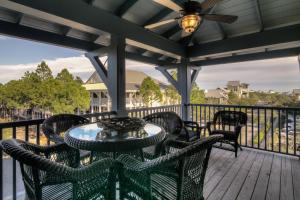 a patio with a table and chairs on a deck at Lighthouse Loft in Santa Rosa Beach