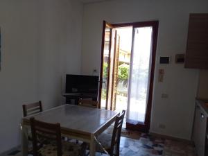 uma sala de jantar com uma mesa e uma porta de vidro deslizante em Bilocale con ingresso indipendente Katia em Massa