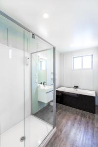a bathroom with a glass shower and a sink at Tekapo Blue Cottage in Lake Tekapo