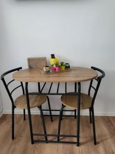 een houten tafel met twee stoelen en een tafel met eten erop bij Apartman Dia Sarajevo in Sarajevo