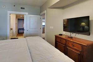 1 dormitorio con 1 cama grande y TV de pantalla plana en Grand Panama Beach Resort - The Grand 403 en Panama City Beach