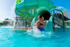 un hombre y una mujer en un tobogán de agua en una piscina en Paradisus Playa del Carmen - Riviera Maya - All Inclusive, en Playa del Carmen
