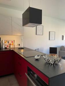 a kitchen with red cabinets and a black counter top at Appartement de standing piana in Piana