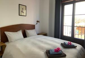 a bedroom with a bed with towels and a window at Boutique Hostal Lorca in Nerja