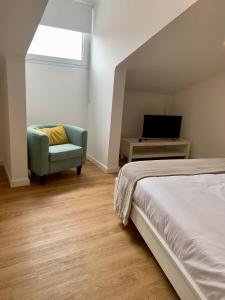 - une chambre avec un lit, une chaise et une télévision dans l'établissement Apartamento Sta Catarina - Sta Catarina Place, à Ponta Delgada