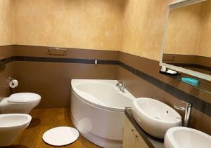 a bathroom with a tub and a toilet and a sink at Serena Apartment in Lucca