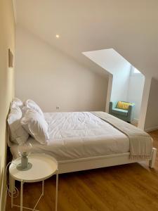 - une chambre blanche avec un lit et une table dans l'établissement Apartamento Sta Catarina - Sta Catarina Place, à Ponta Delgada
