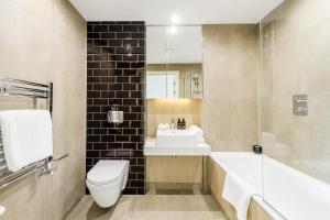 a bathroom with a sink and a toilet and a tub at Quaint Montana in London