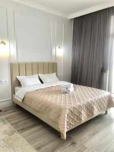um quarto com uma cama grande e almofadas brancas em Premium Apartments Esil Riverside em Astana