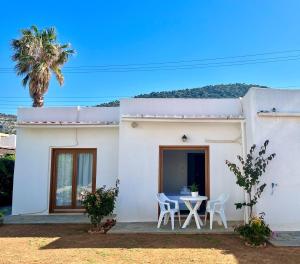 a white house with a table and chairs at Kali Holiday Apartments in Stalida
