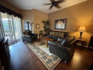 sala de estar con sofá y ventilador de techo en Sunny`s Florida Villa, en Haines City