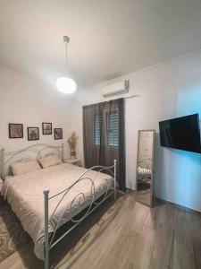 Schlafzimmer mit einem Bett und einem Flachbild-TV in der Unterkunft Paradise House in Arkoudi