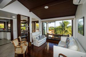 a living room with white furniture and large windows at BZ20 Geribá com vista panorâmica! 6 quartos in Búzios