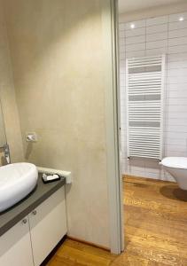 a bathroom with a white sink and a toilet at Serena Apartment in Lucca