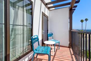 two blue chairs and a table on a balcony at Marea Sol Hotel in Santa Cruz