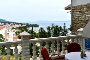 a balcony with a table and chairs and the ocean at Draga & Lola in Baška Voda