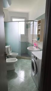 een badkamer met toilet en wastafel en wasmachine bij Relax Rental in Vlorë