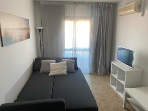 sala de estar con sofá y TV en Punta Umbria ideal apartamento Enebrales, en Punta Umbría