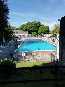 a large swimming pool with chairs and people in it at 2 bed Villa with full use of site facilities in Newquay