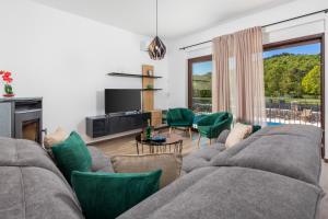 sala de estar con sofá gris y sillas verdes en Villa Jasna, en Čavle