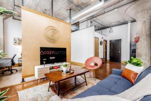 a living room with a blue couch and a table at CozySuites Stunning 1BR Adler Loft with Parking in Saint Louis