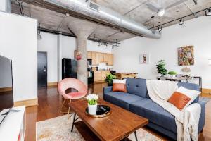 a living room with a blue couch and a table at CozySuites Stunning 1BR Adler Loft with Parking in Saint Louis