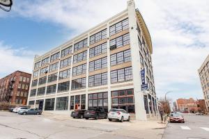 a large building with cars parked in front of it at CozySuites Stunning 1BR Adler Loft with Parking in Saint Louis