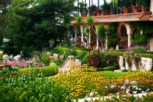 a garden with flowers in front of a building at La Playa Hotel in Carmel