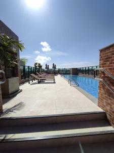 a swimming pool with benches and the ocean in the background at Sweet home in Maceió