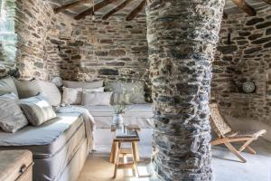 a living room with a couch and a stone wall at Onos Eco Living in Mési