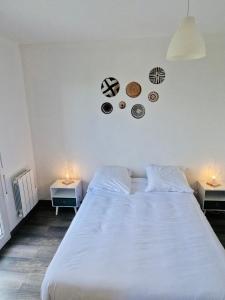 sypialnia z dużym białym łóżkiem z dwoma stołami w obiekcie Appartement Cosy Joué-Les-Tours w mieście Joué-lés-Tours