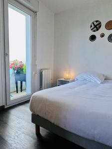 um quarto com uma cama grande e uma janela grande em Appartement Cosy Joué-Les-Tours em Joué-lés-Tours