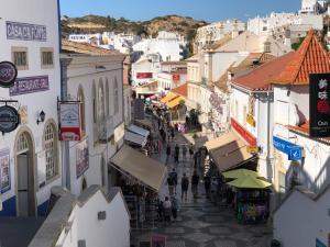 a group of people walking down a street with buildings at Apartamento Flor de Amendoeira in Albufeira