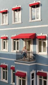 Galata Design Hotel في إسطنبول: امرأة جالسة على شرفة مبنى