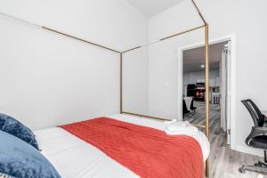 een slaapkamer met een bed en een grote spiegel bij 2BR Park Ave Townhome with parking CozySuites in Saint Louis