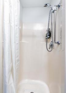 a white bathroom with a shower and a toilet at CozySuites CWE 2 queen bed suite in Saint Louis