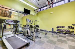 a gym with treadmills and machines in a room at CozySuites Stunning 2BR penthouse Skyline view in Saint Louis