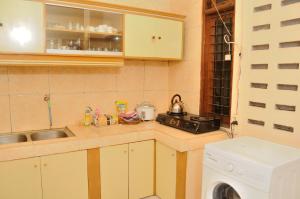 a kitchen with a sink and a washing machine at Joyful Home in Yogyakarta