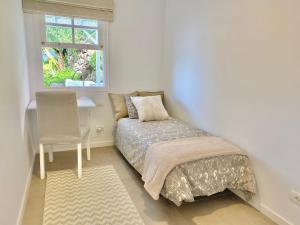 Un dormitorio con una cama y un escritorio y una ventana. en Casa Calma, Private Paradise with Sea View, en La Orotava 39 fotos más