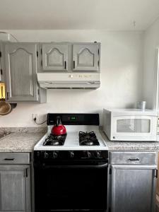 a kitchen with a black stove and a microwave at Simple Deluxe Private Room in Anchorage