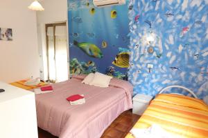 1 dormitorio con un mural de pescado en la pared en Le Gardenie b&b, en Marina di Schiavonea
