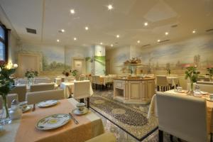 ein Restaurant mit Tischen und Stühlen und einem Gemälde an der Wand in der Unterkunft Hotel Condor in München