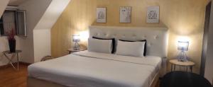 1 dormitorio con 1 cama blanca grande y 2 lámparas en Hotel Zona G en Bogotá